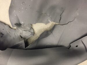 Foam cushion and cover after accelerated life cycle testing. The cover is cracked and torn.