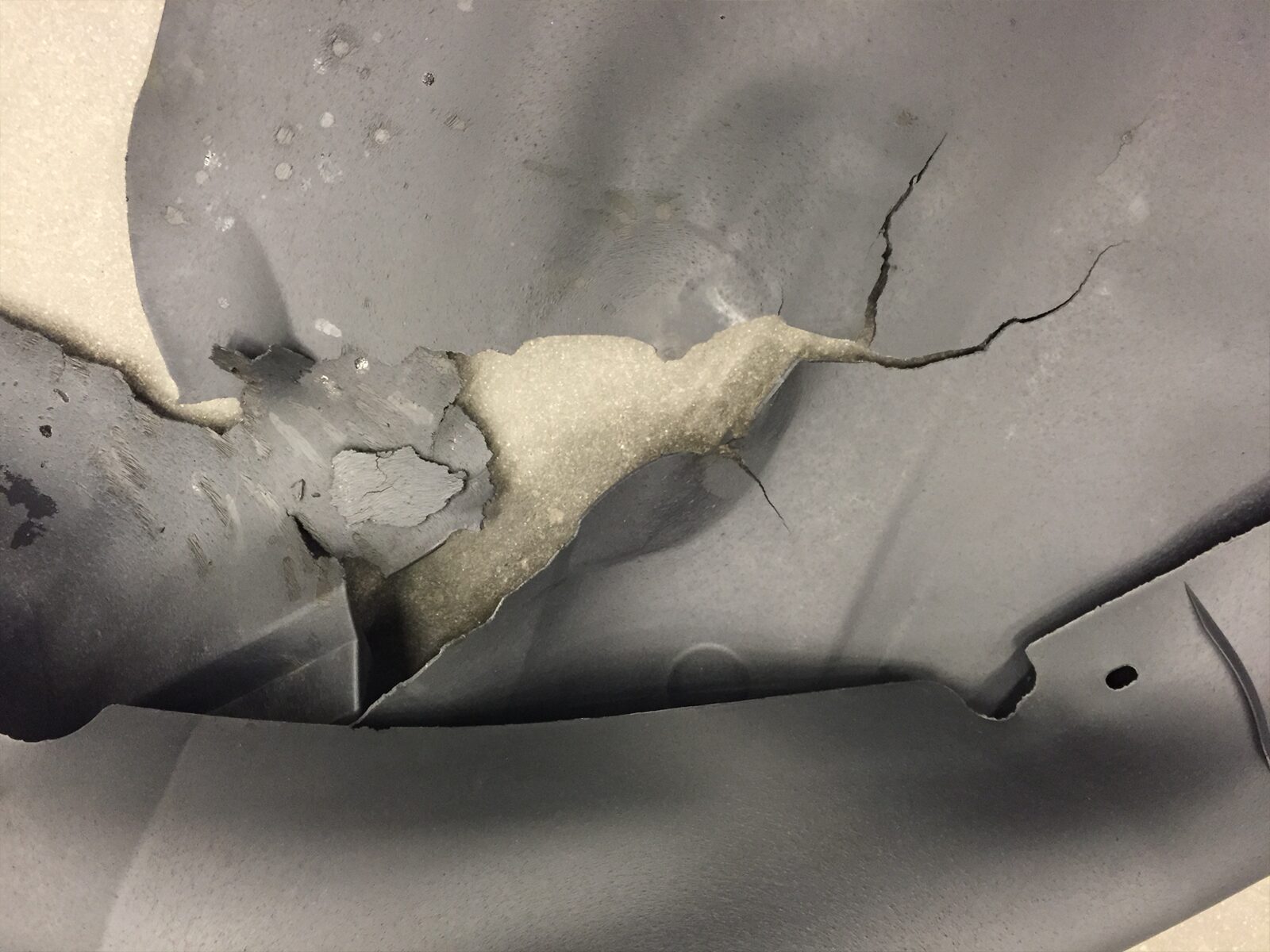 Foam cushion and cover after accelerated life cycle testing. The cover is cracked and torn.