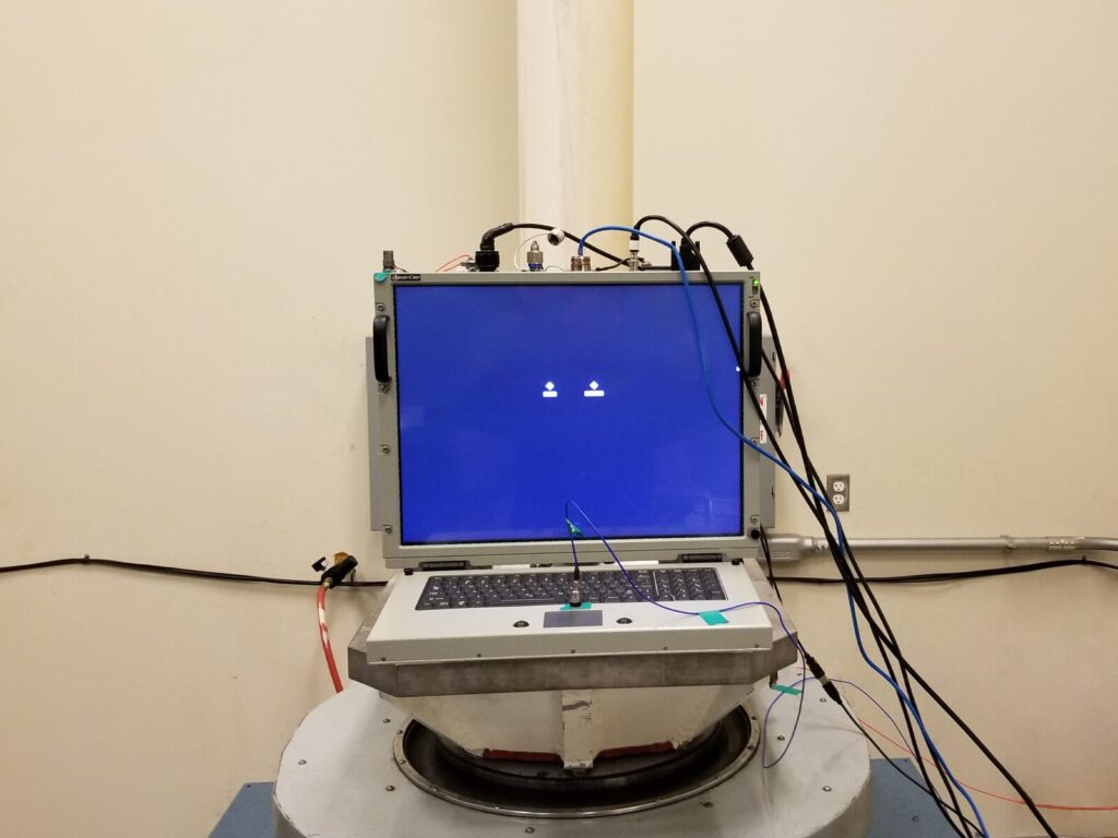 Computer strapped to a vibration table for mechanical shock testing