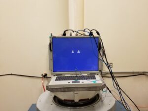 Computer strapped to a vibration table for mechanical shock testing