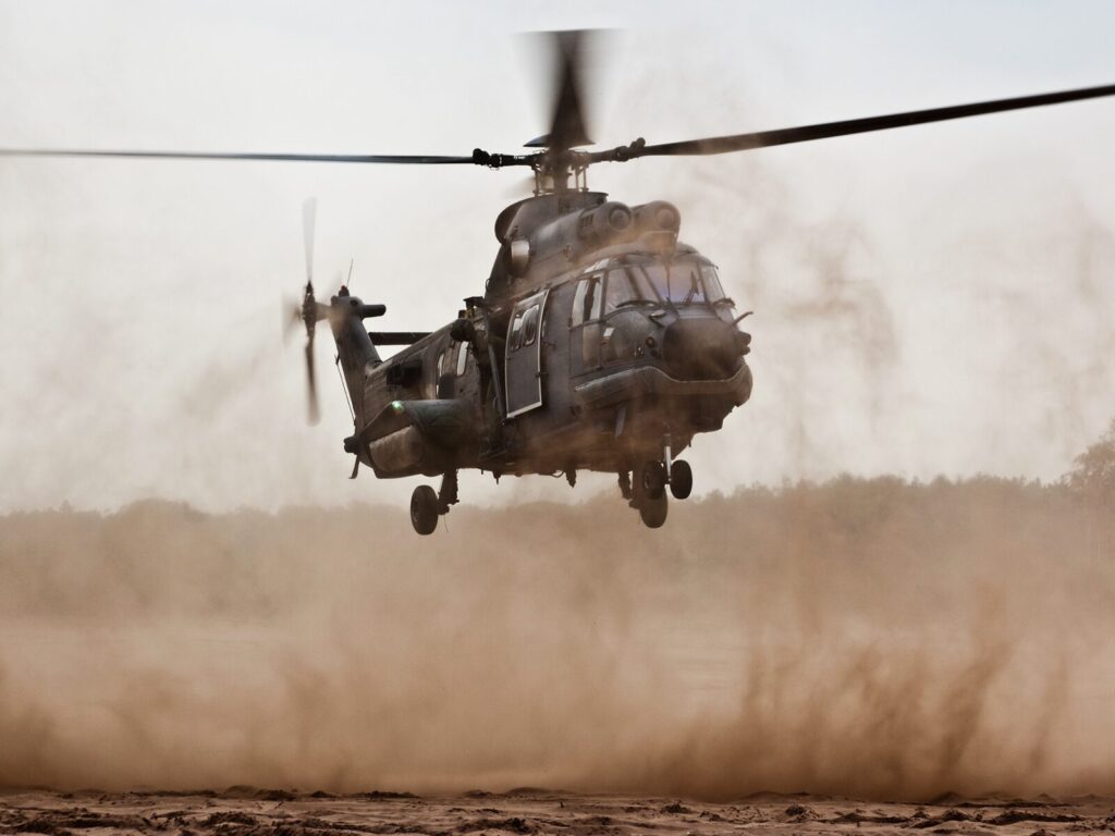 Military helicopter landing in a desert