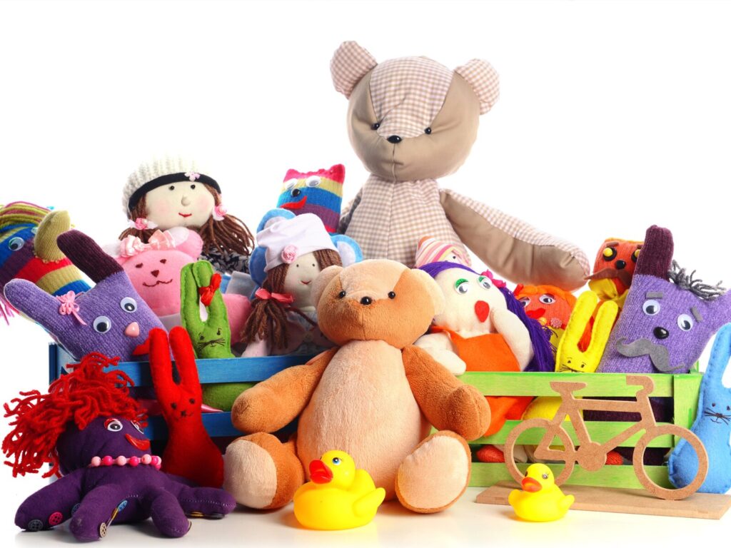 Children's stuffed animals and rubber ducks against a white background