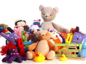Children's stuffed animals and rubber ducks against a white background