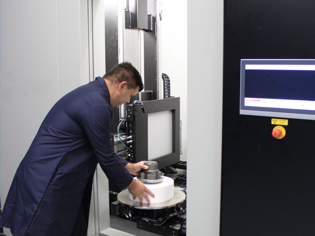 An expert loads a component into a 3D computed tomography scanner