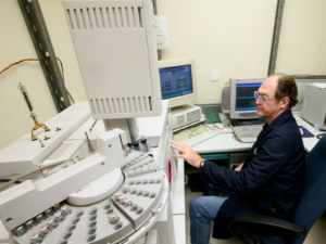 Chemist operates a gas chromatograph and mass spectroscopy detector for phthalate testing