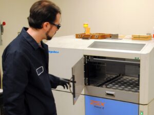 A chemist prepares a Rigaku Primus II ESX Spectrometer for wavelength dispersive X-ray fluorescence testing.