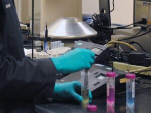 Chemist handles a liquid sample for wet chemical analysis.