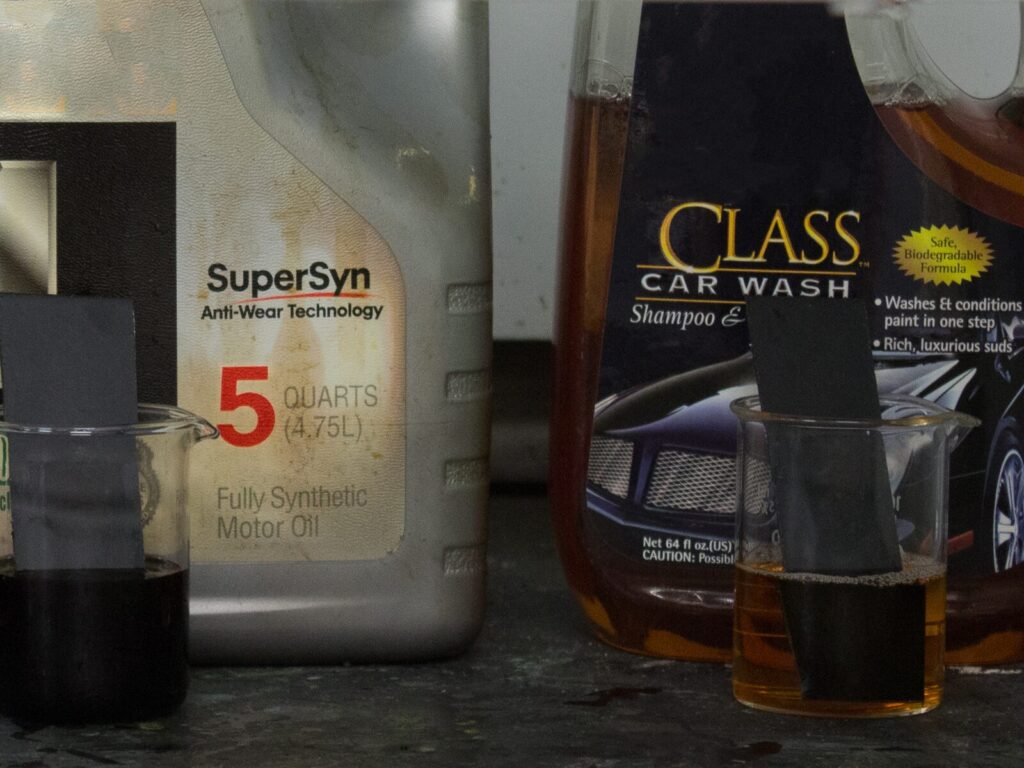 Motor oil and car shampoo containers and liquid samples for chemical resistance testing