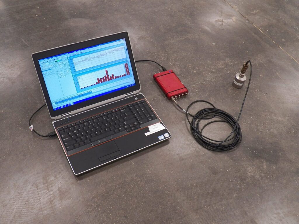 Laptop plugged into a concrete floor for vibration analysis