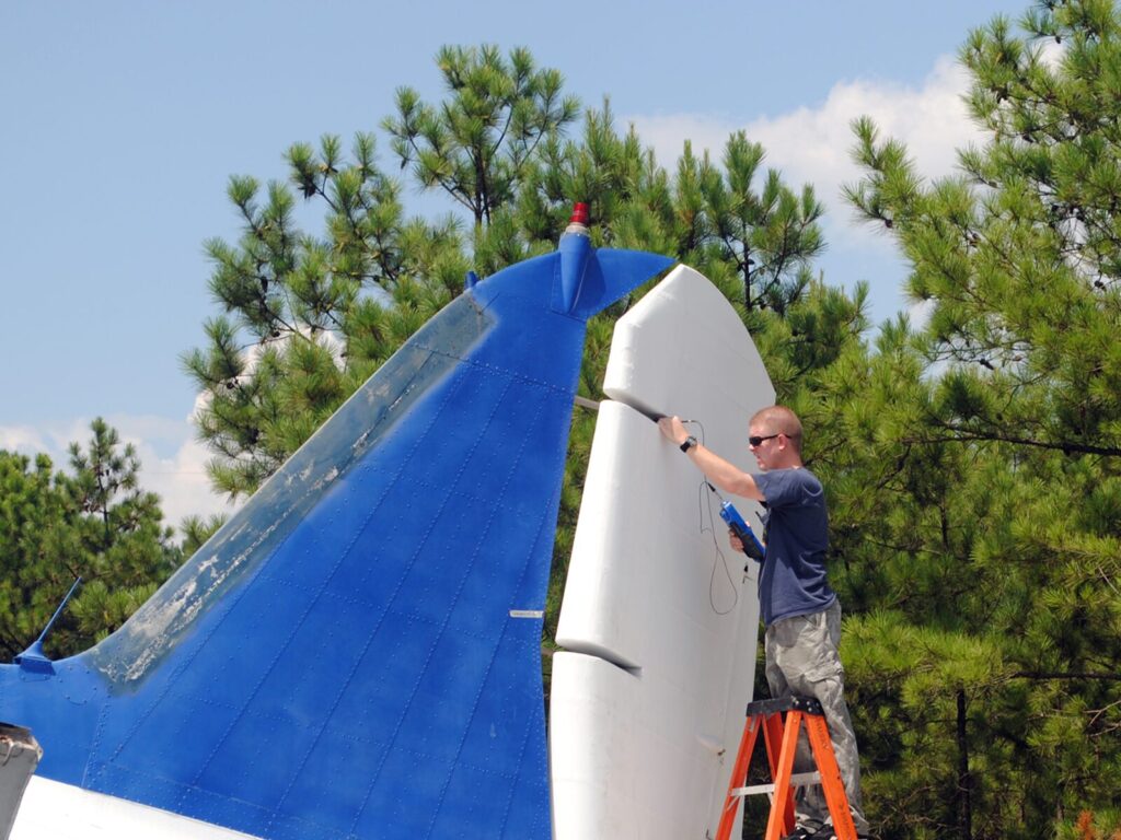 Nondestructive testing expert performs an Eddy current test on a commercial plane rudder.