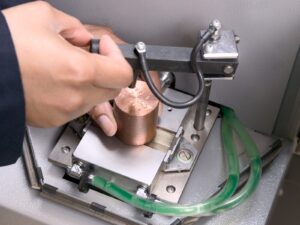 Technician adjusts a copper sample for optical emission testing.