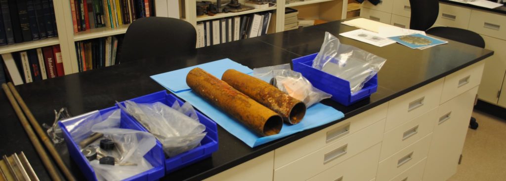 Corroding metal pipes waiting to undergo Metals Analysis