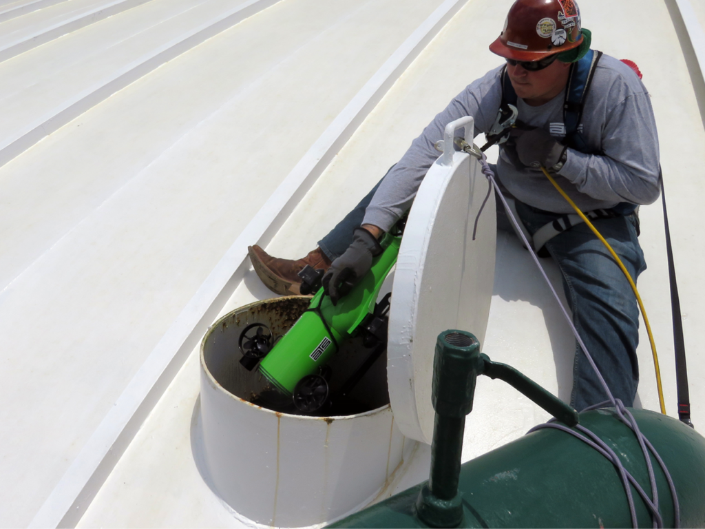 Technician inserting ROV in a tank