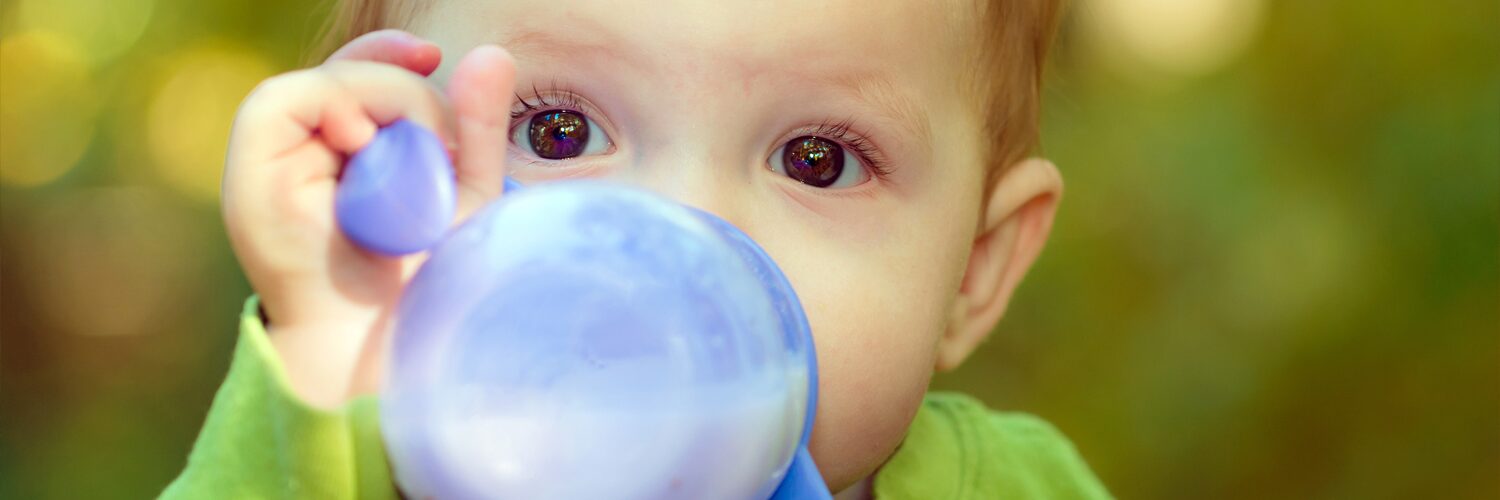 Infant drinks from a sippy cup