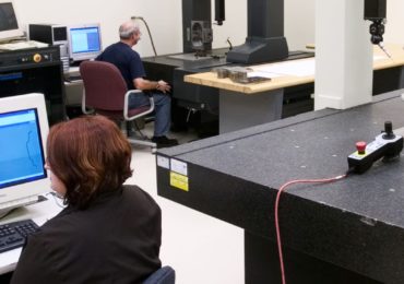 Technicians Performing a Dimensional Analysis on a Client Sample Using CMM