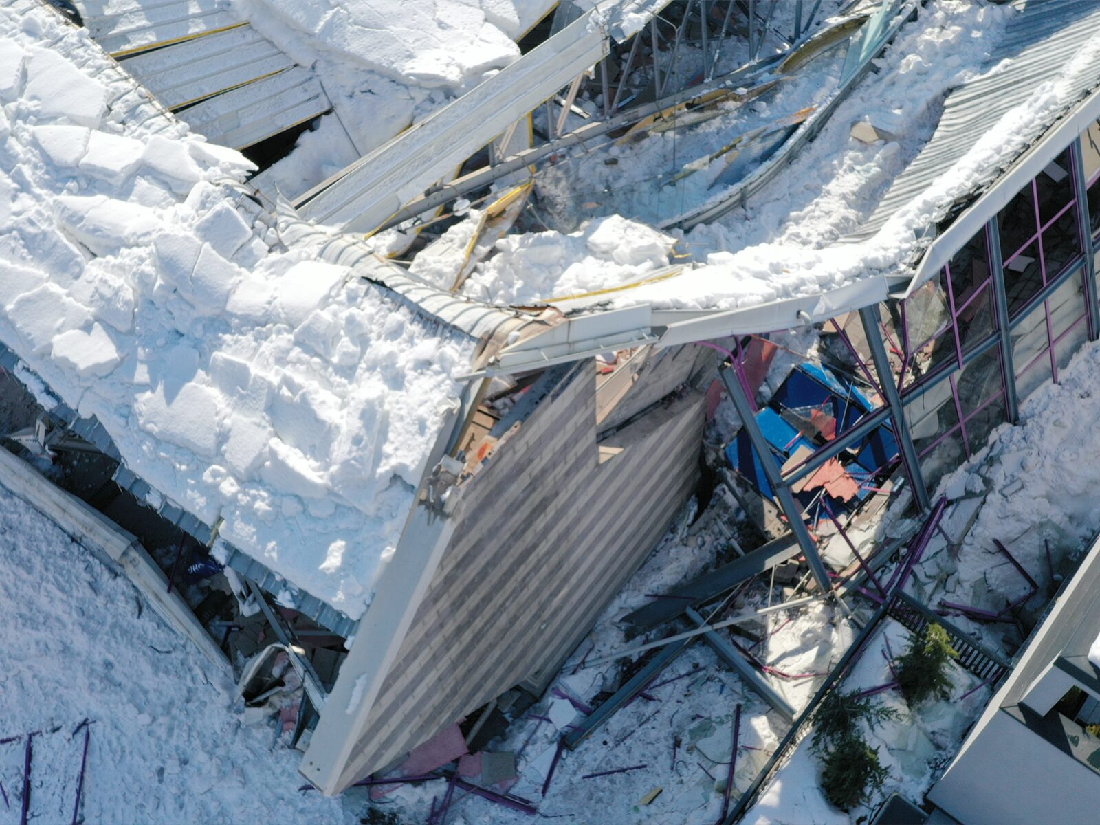 Overhead view of a roof partially collapsed under snow