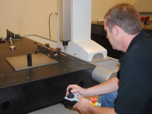 Lab technician operates a coordinate measurement machine