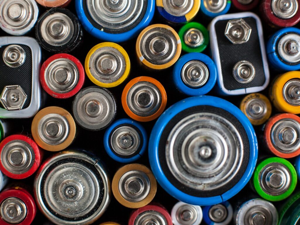 A collection of multicolored batteries of various shapes and sizes.
