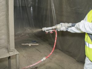 Technician sprays a structure with a fireproofing treatment