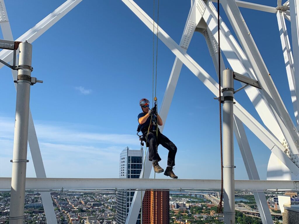 Rope access technician suspended from a bridge