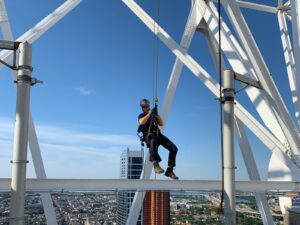 Rope access technician suspended from a bridge