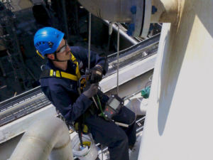 Rope access technician prepares to inspect a pipe