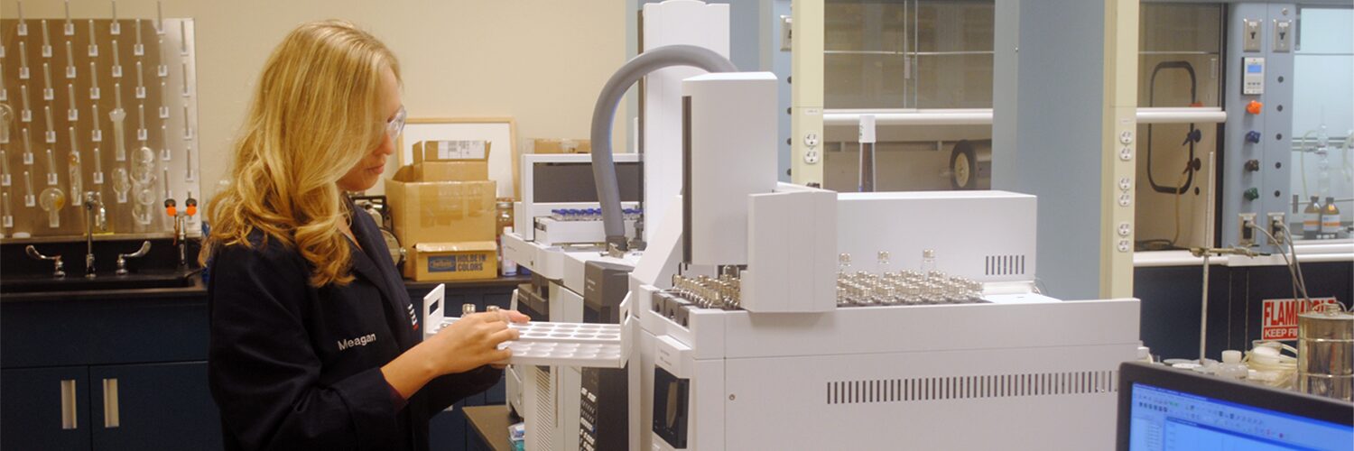 Chemist removes a sample from a gas chromatography chamber