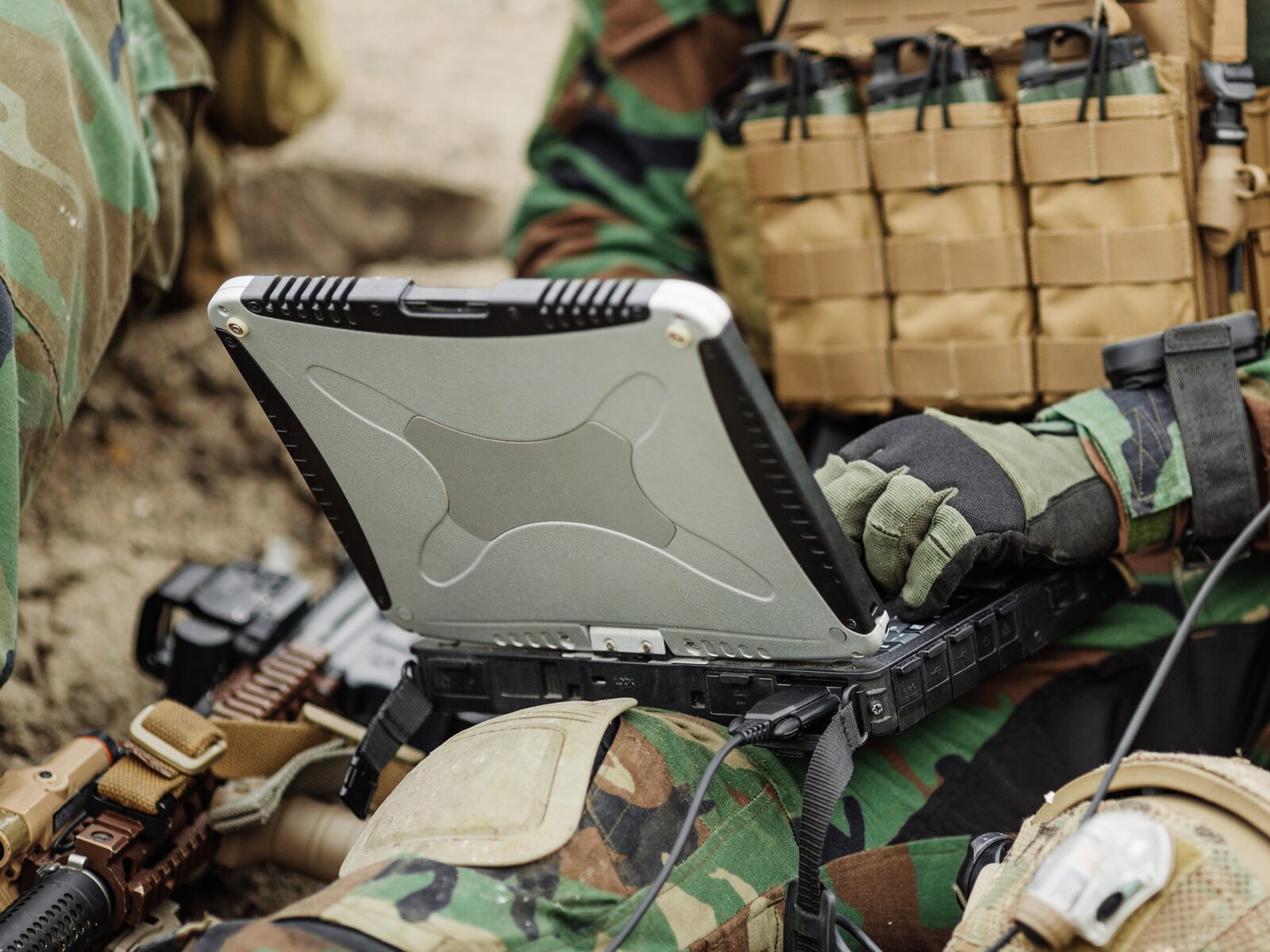 A soldier operates a laptop with military-grade protective casing