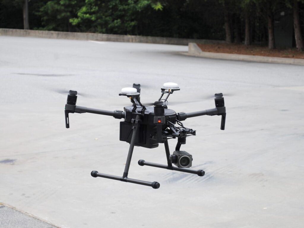 Unmanned aerial vehicle (a drone) hovers over concrete