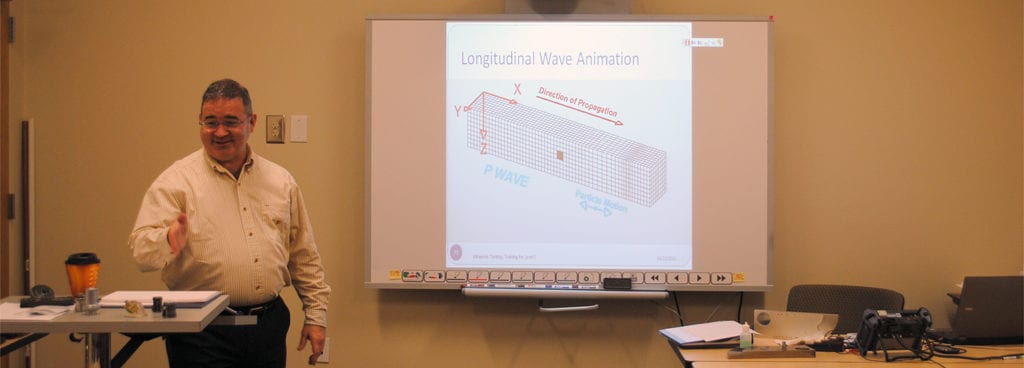 Instructor Illustrating Principles of Wave Propagation for Ultrasonic Course