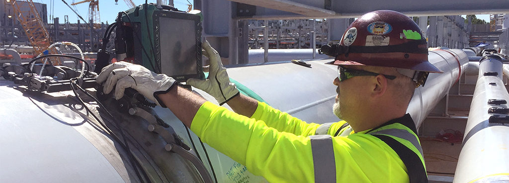 technician inspecting a large pipe