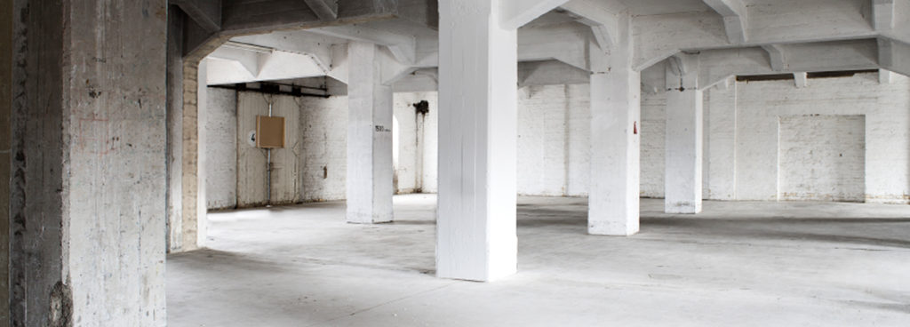 inside of an industrial concrete building with concrete slab pillars