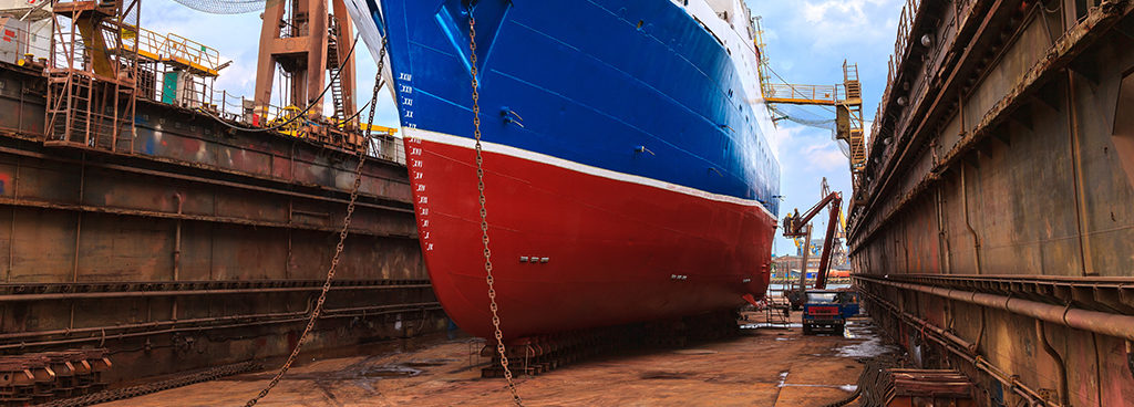red and blue ship inside dry dock bay