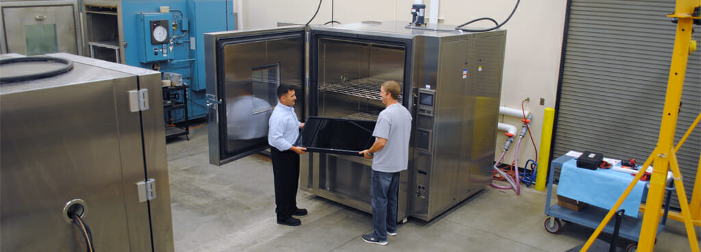 Two Technicians Loading a Sample Into a Thermal Chamber