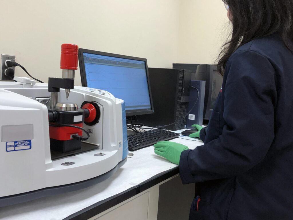 Chemist performs Fourier Transform Infrared Spectroscopy to identify materials in a sample.