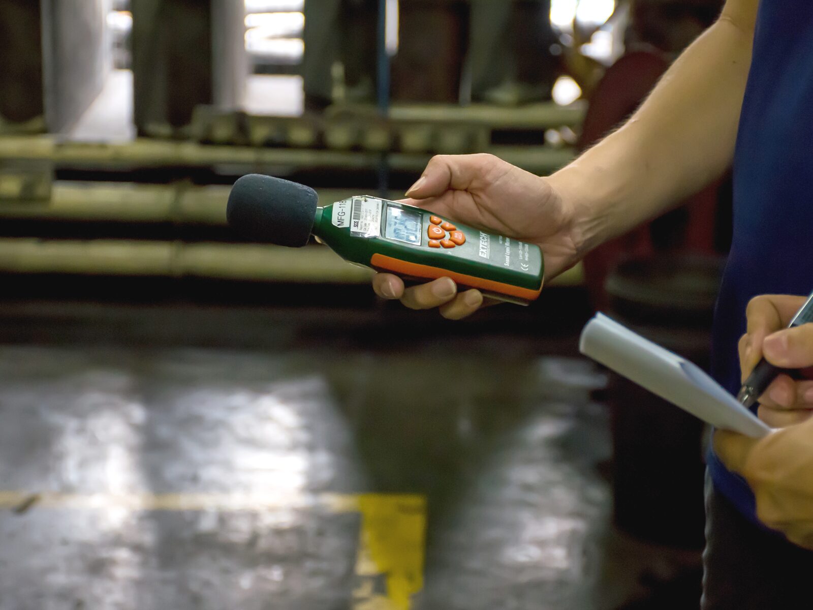 Technician holds a noise dosimeter