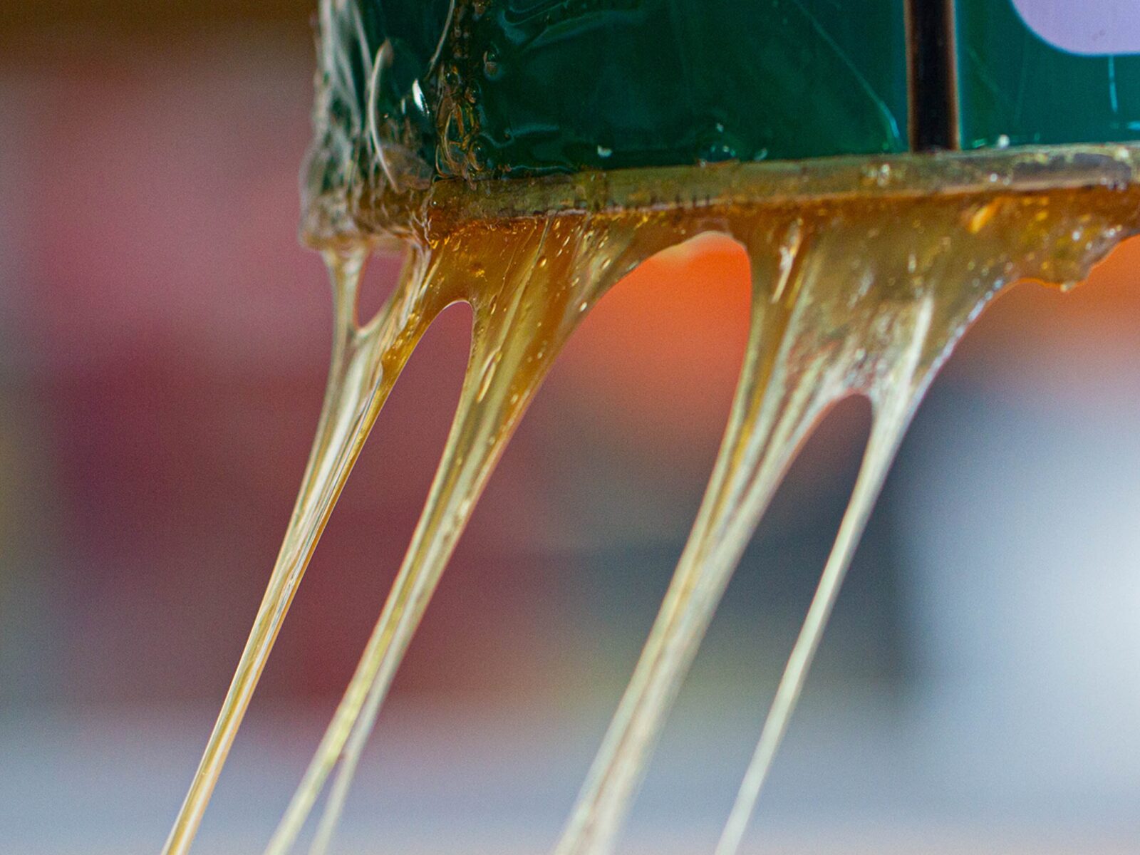 A rubber adhesive stretches in thick strings during an adhesion test, which it fails