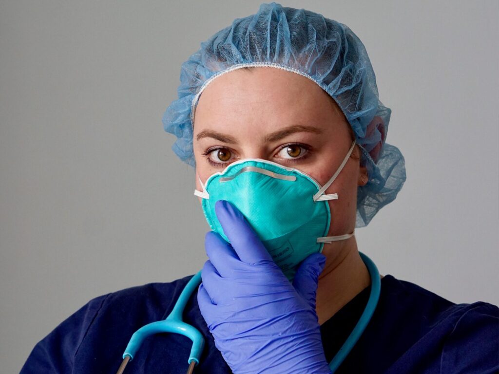 Nurse wearing personal protective equipment (PPE): a Bouffant hair cap, a face mask, and gloves.