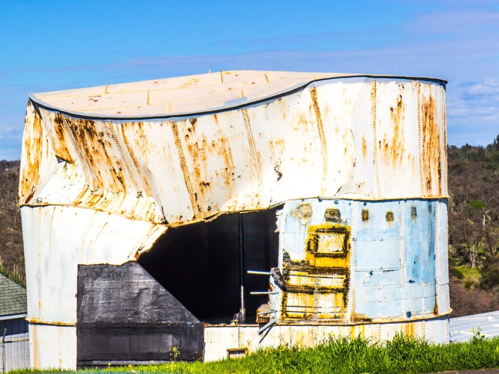 A rusted and crushed aboveground tank