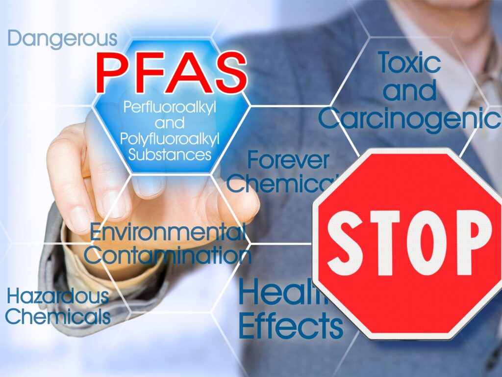 Concept: man points to a hexagon that says "PFAS." A drawing of stop sign is in the bottom corner of the picture.