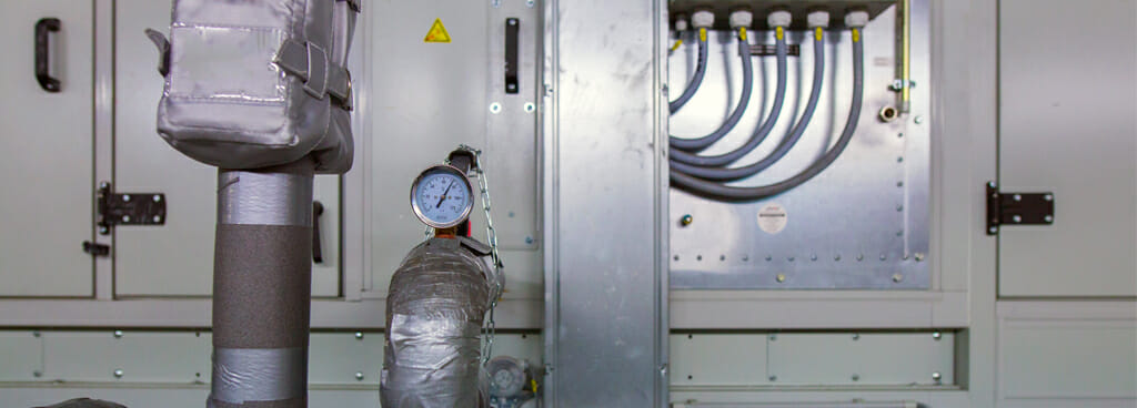 Humidity, temperature, and pressure controls at an industrial site. Metal pipes and wires are in the background.
