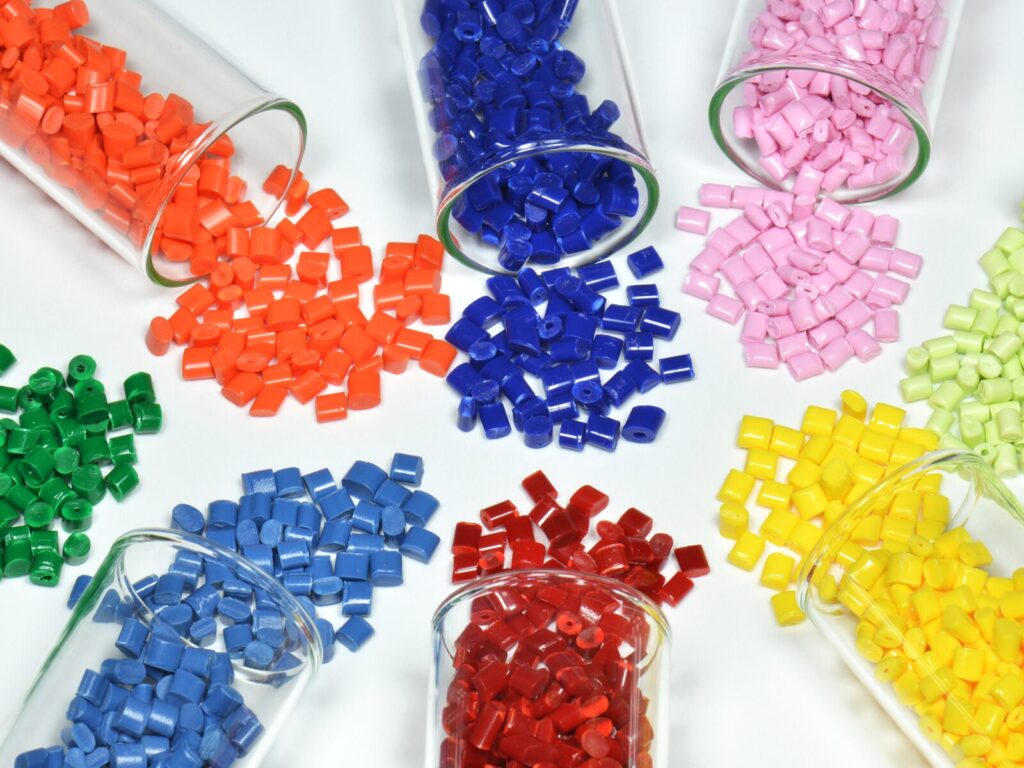 Six plastic tubes with multi-colored polymer beads spilling out in all directions