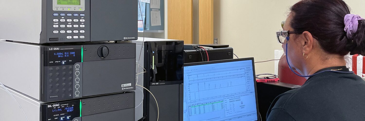 Chemist studies ion chromatography test results on a computer monitor