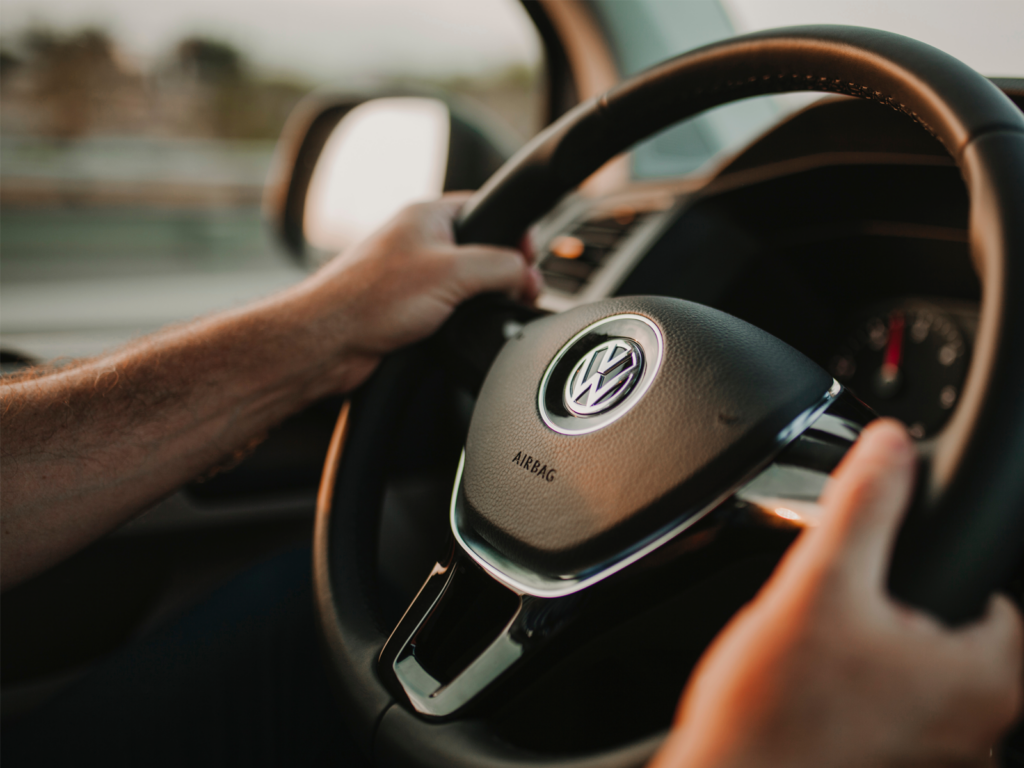 Driver's hands on a Volkswagen steering wheel