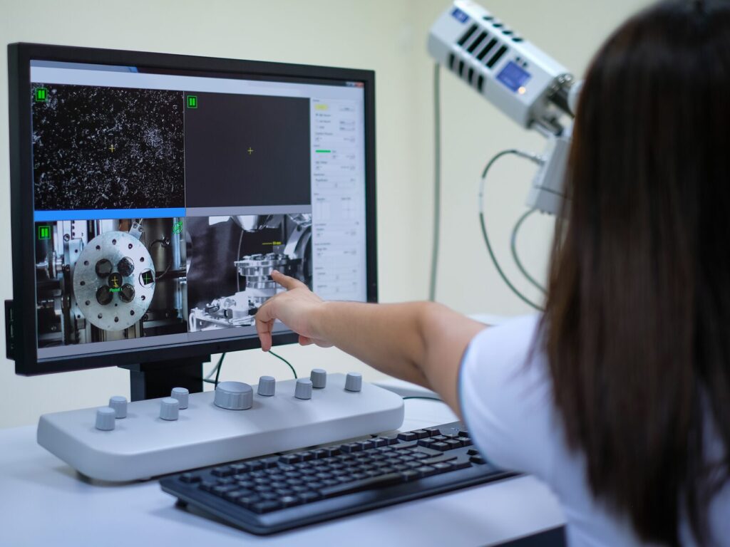 Experts points to a computer screen displaying metallurgical scans.