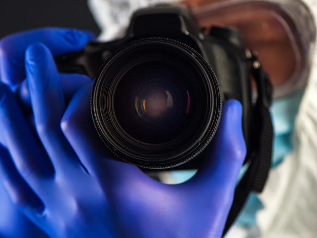 Close up on a forensic examiner taking a picture with a camera