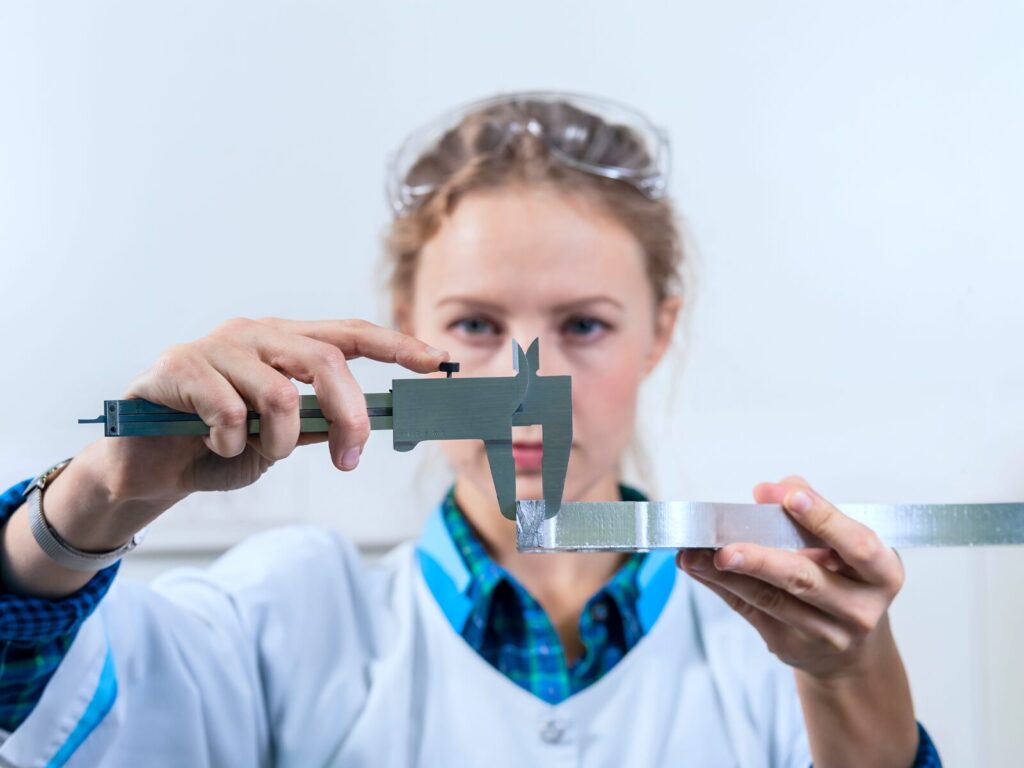 Forensic engineer measures the width of a fractured metal specimen with a length gauge