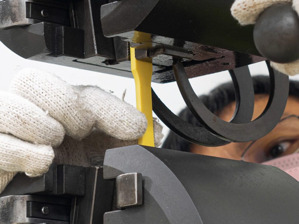 Focus on a technician positioning a plastic coupon for tensile testing