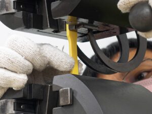 Focus on a technician positioning a plastic coupon for tensile testing