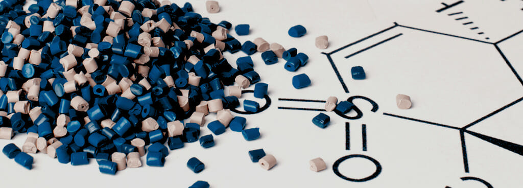 Blue and grey plastic pellets spill onto a mat before GPC Polymer Characterization testing.